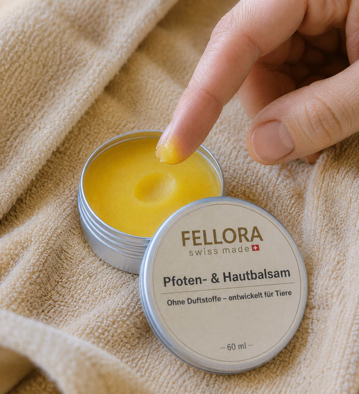 Eine kleine Menge Fellora Pfotenbalsam mit dem Finger aufnehmen